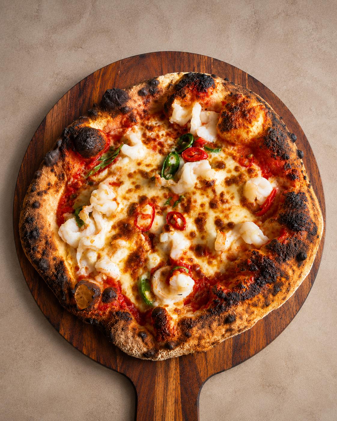 Wood-fired chilli prawn pizza with rocket and lemon