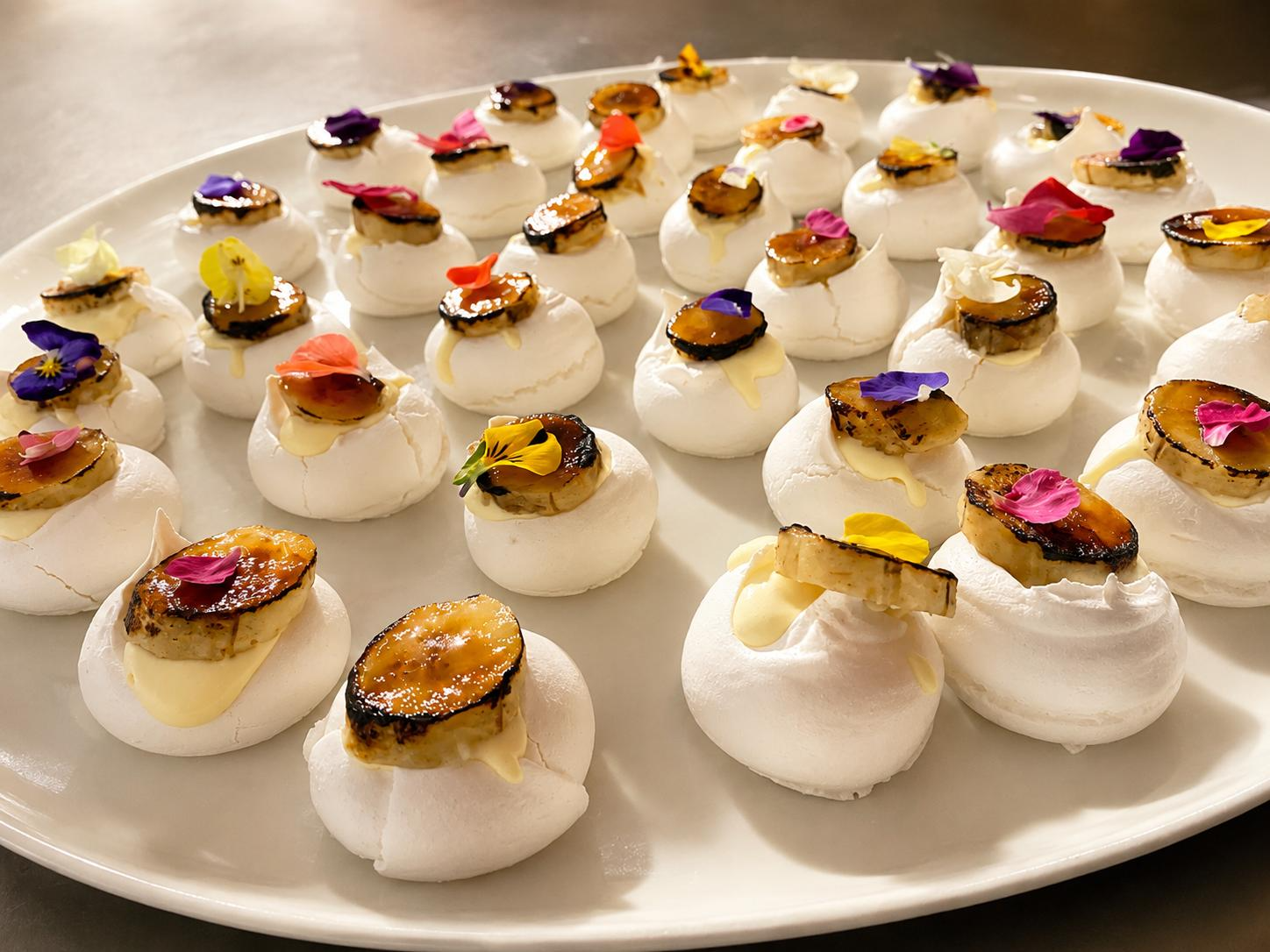 Platter of passionfruit meringues topped with brûléed banana