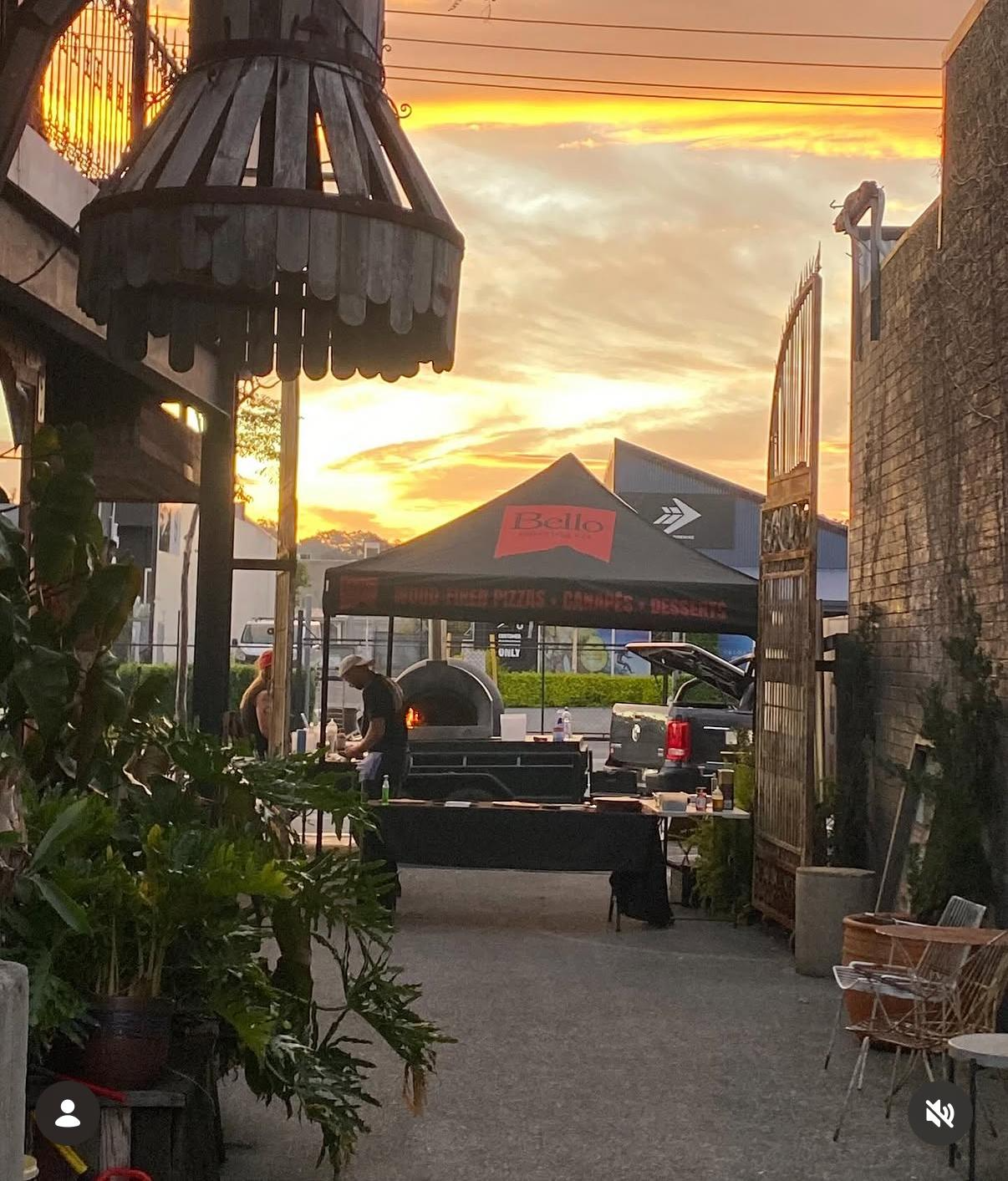 Bello branded pop-up pizza stall and oven trailer at sunset