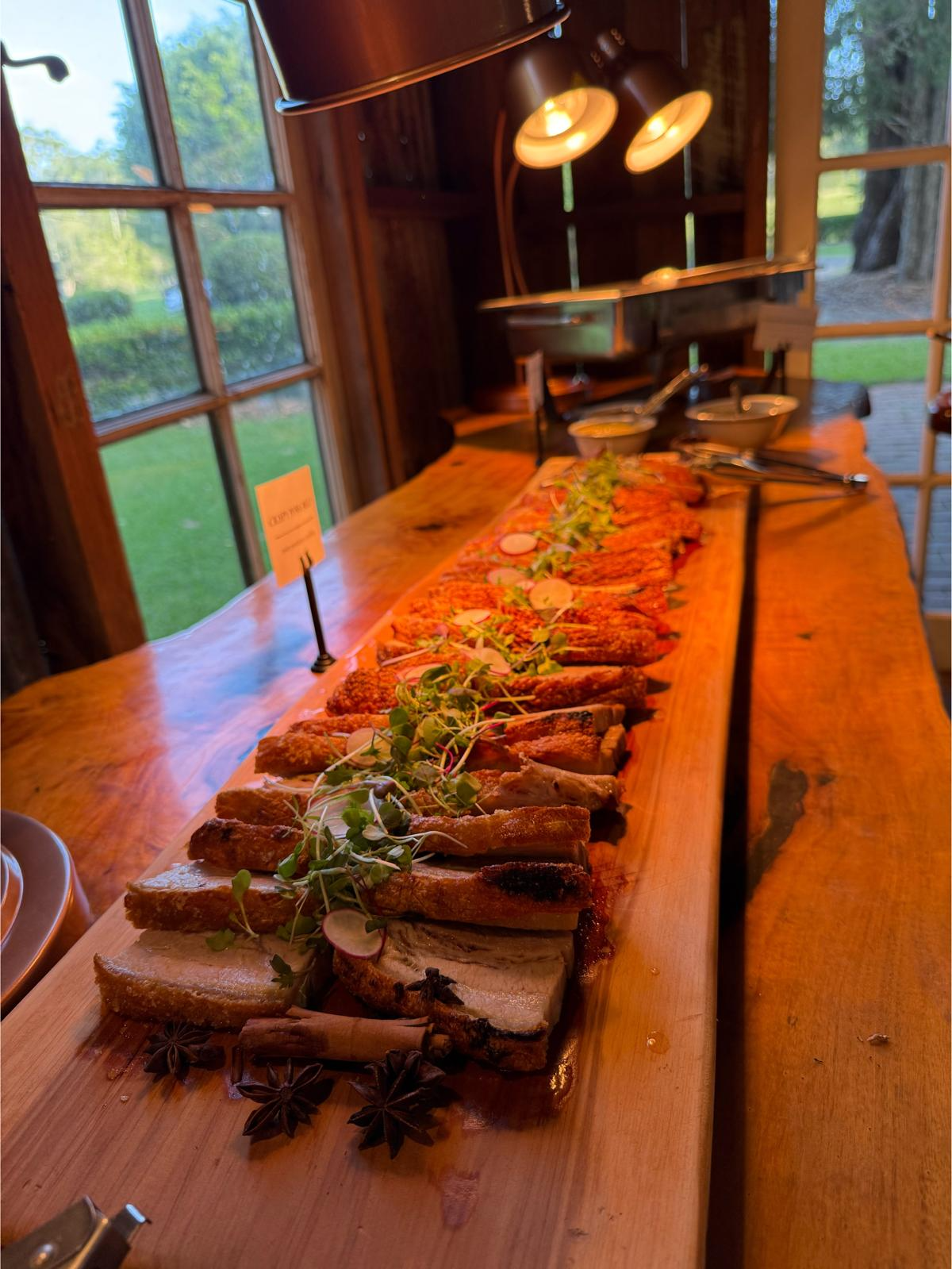 Long table laid with shared woodfired pizzas, salads and sides at an event