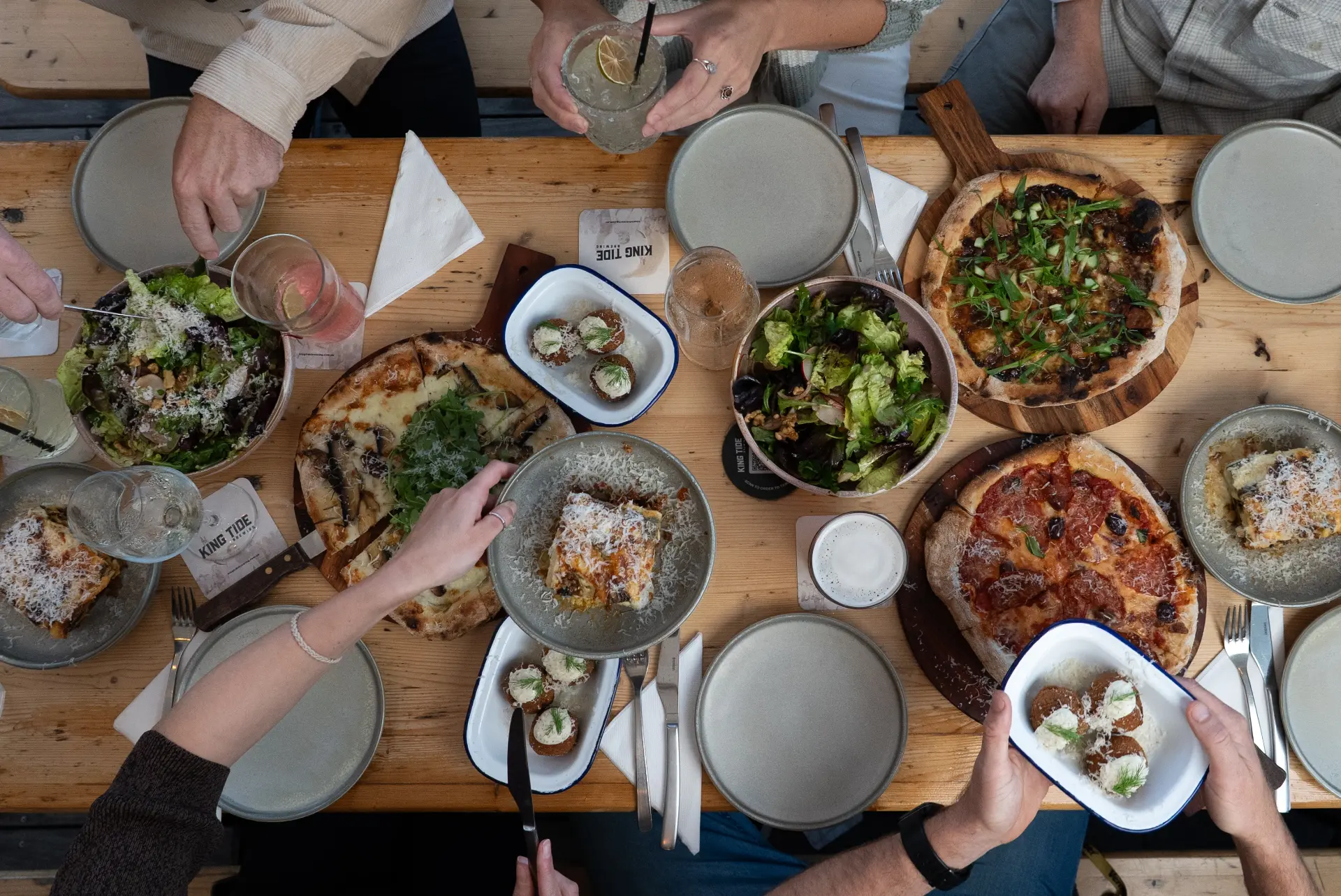 Overhead view of seasonal salads and shared dishes on a banquet table