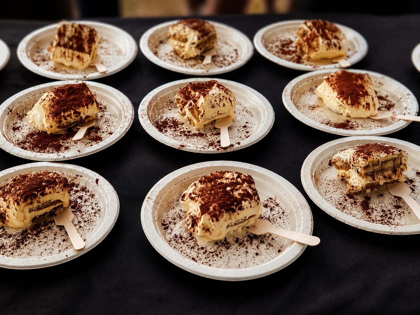 Individual tiramisu portions dusted with cocoa on plates