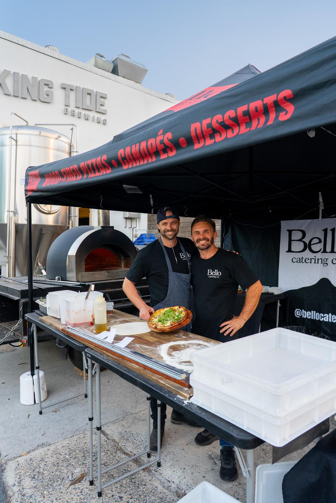 Oliver and Callum with a fresh pizza at the Bello Catering Co. wood-fired oven setup
