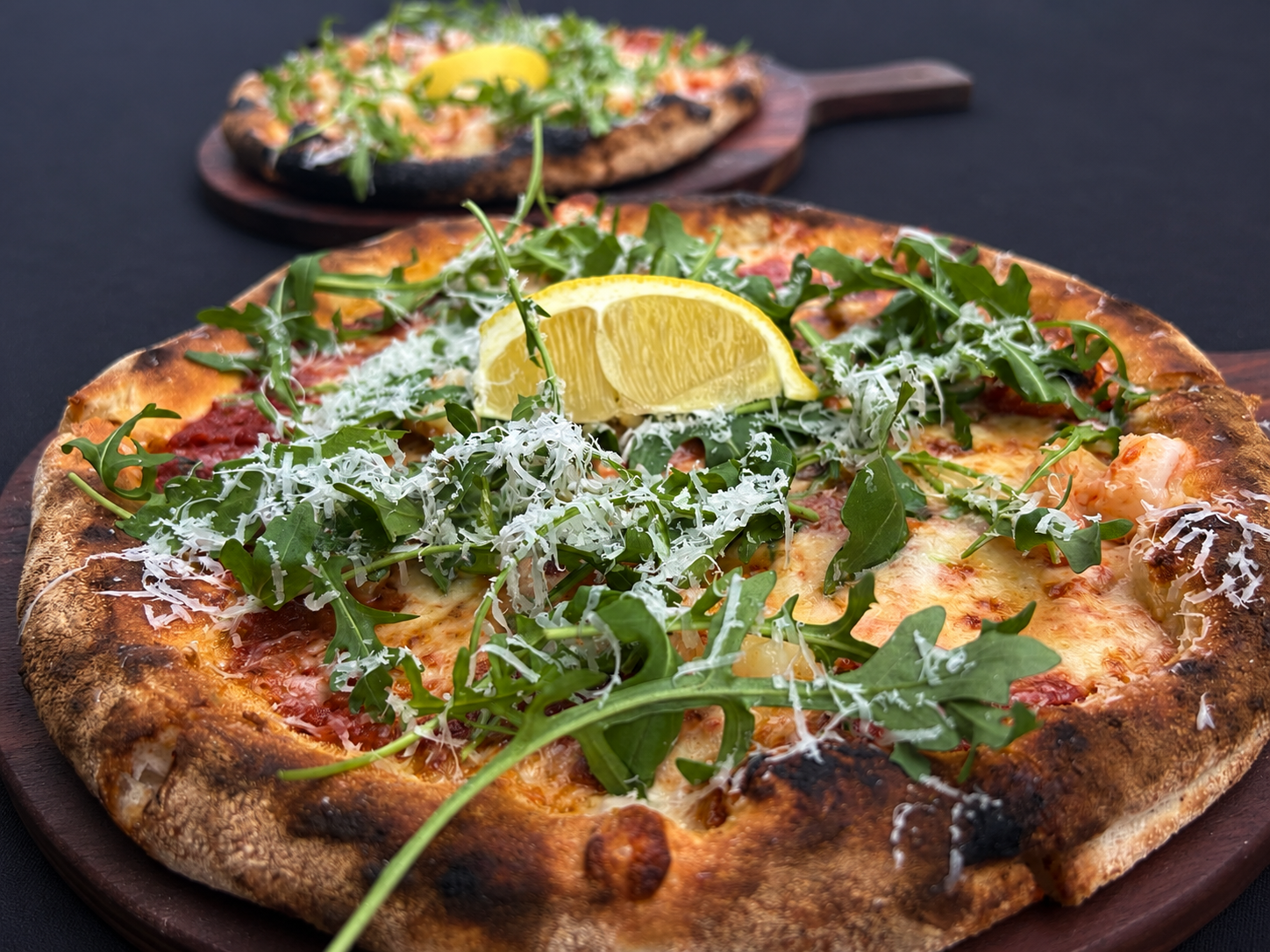Wood-fired Frutti di Mare pizza with prawns, rocket, parmesan and lemon