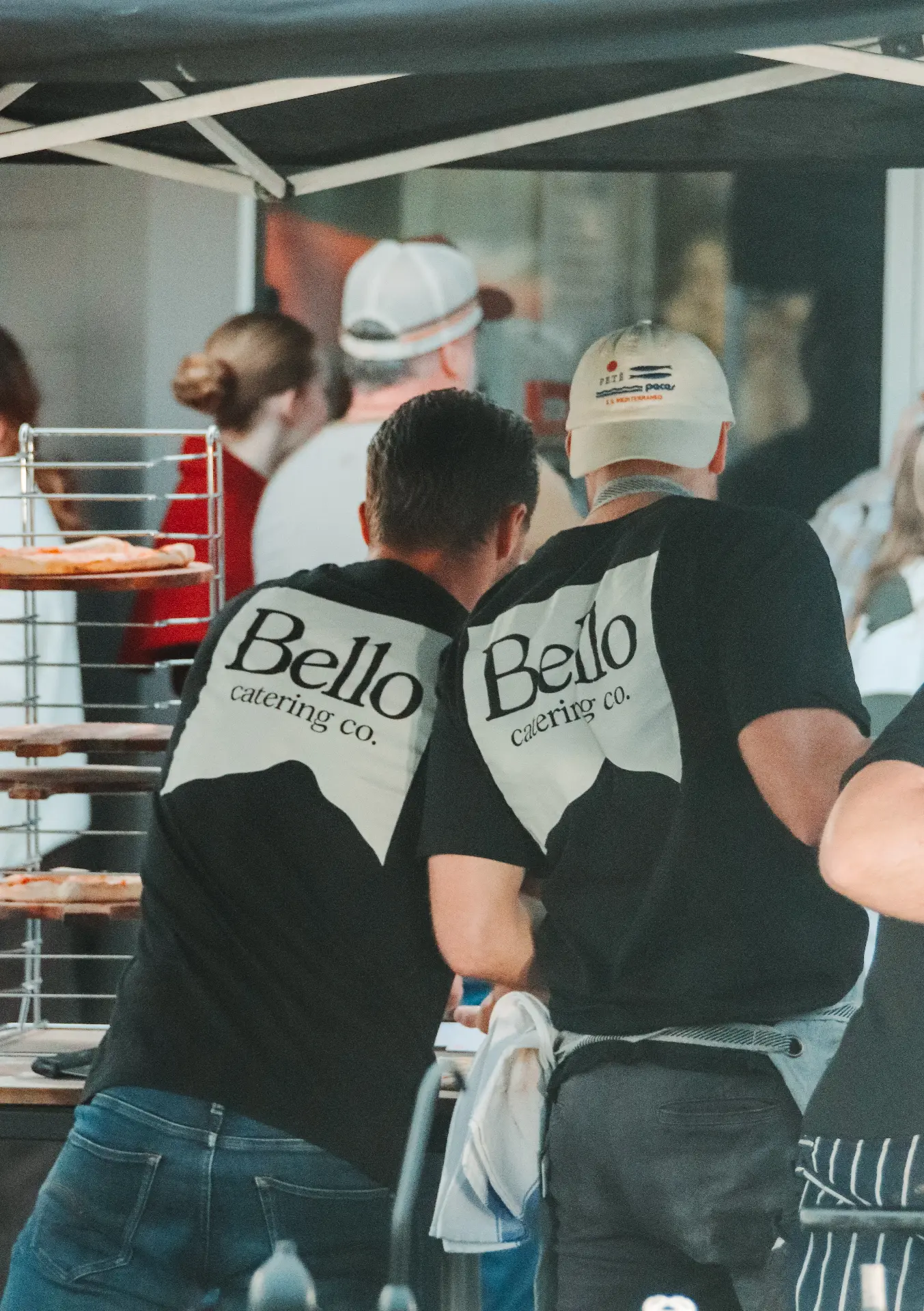 Oliver and Callum at the Bello Catering Co. wood-fired pizza setup under the marquee